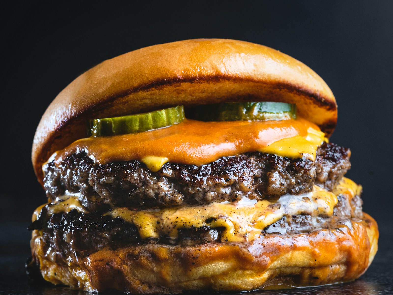 Saftiger Doppel-Cheeseburger vor dunklem Hintergrund