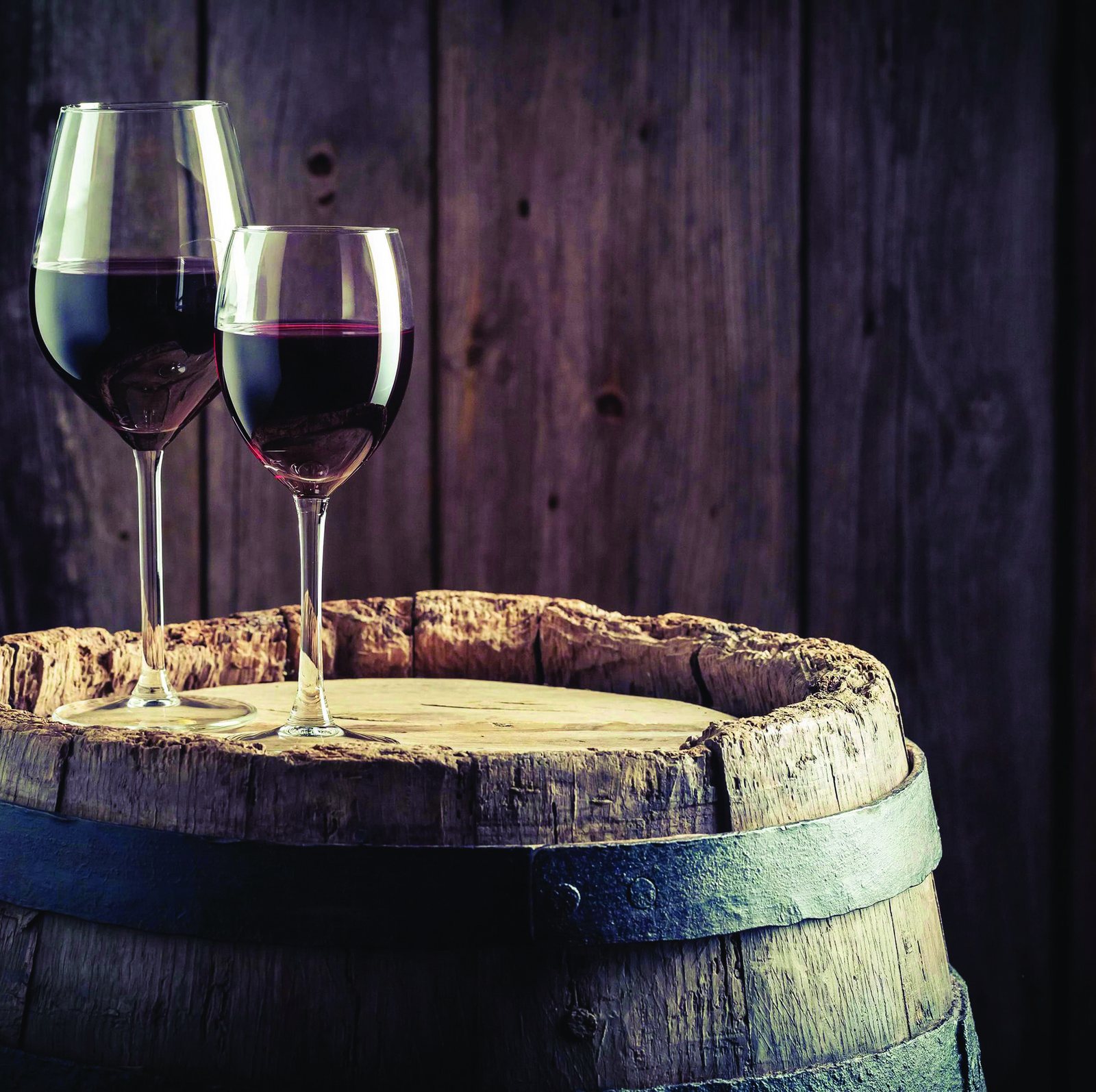 Zwei Gläser Rotwein auf einem alten Weinfass